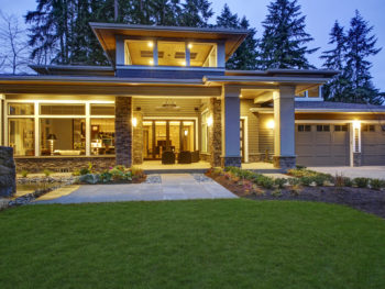 Modern house with well-maintained lawn and garden at dusk