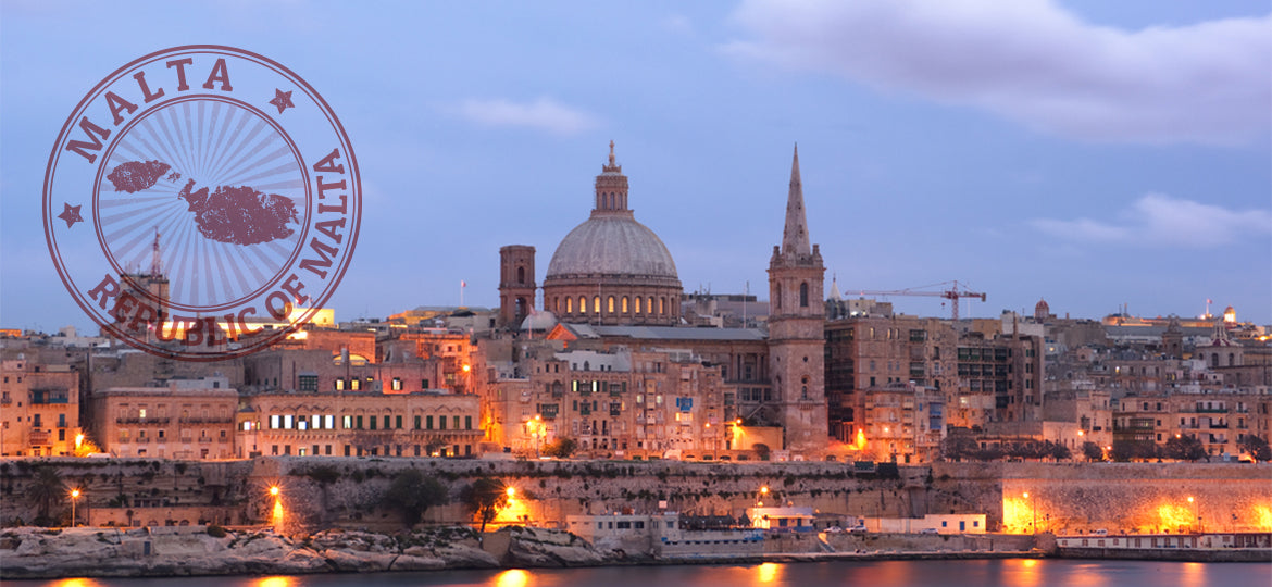 Cityscape of Malta with illuminated buildings and a map stamp in the corner.