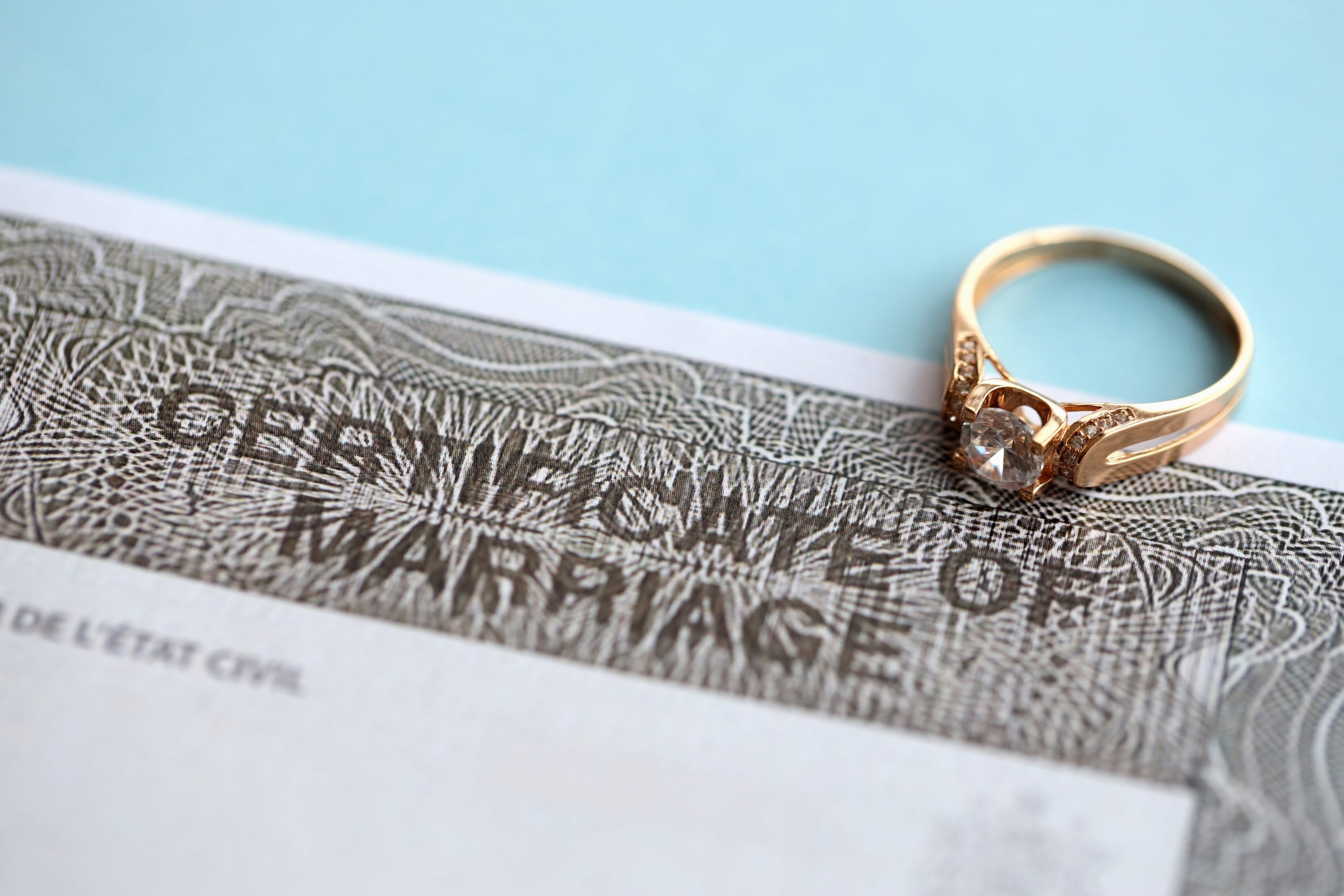 Gold ring on a Certificate of Marriage with a light blue background