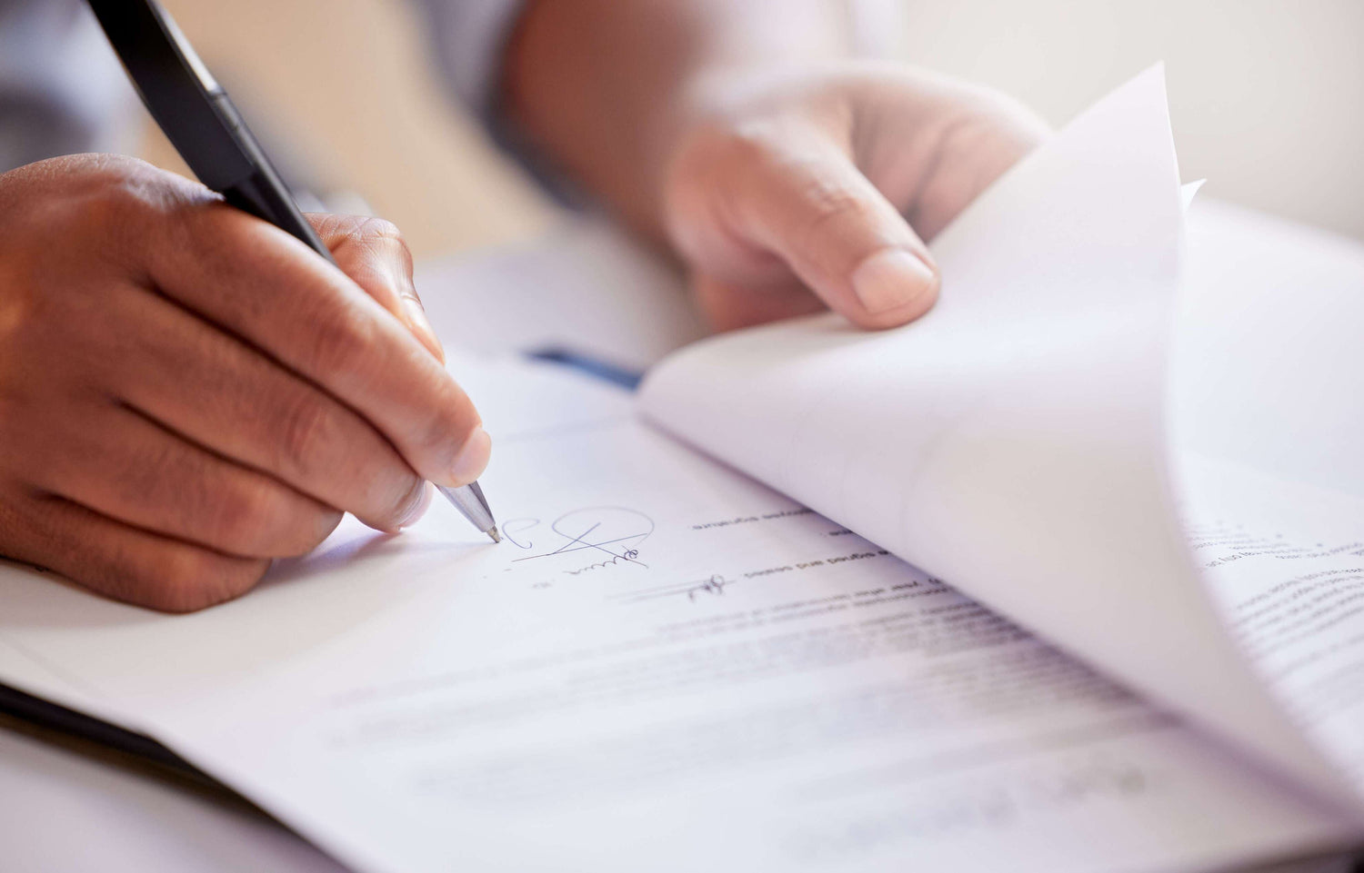 Person writing in a notebook with a pen
