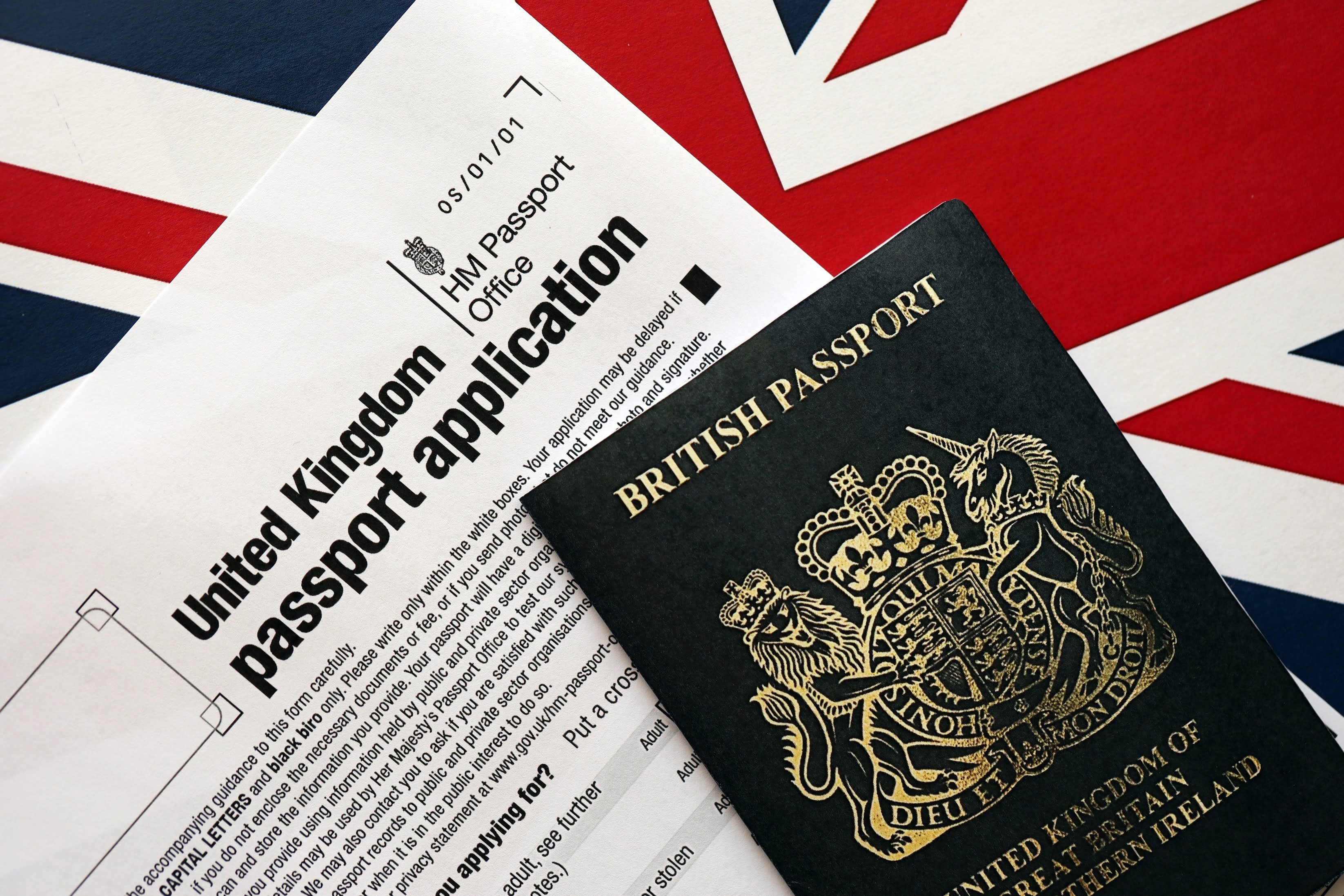 British passport and application form on a Union Jack flag background